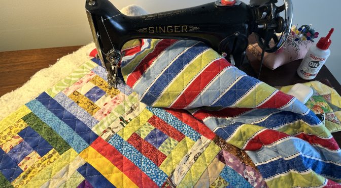 Máquina de costura com retalhos coloridos em bancada